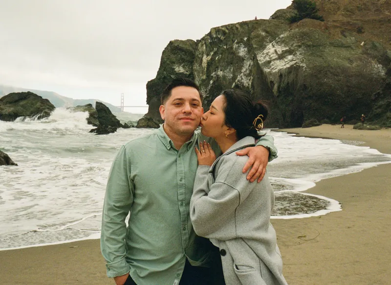 Eden kissing Luis on the cheek on the beach