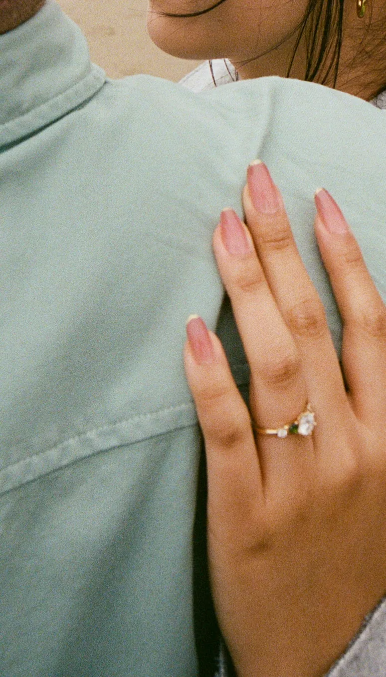 Close-up of Eden’s hand and engagement ring resting on Luis’s shoulder