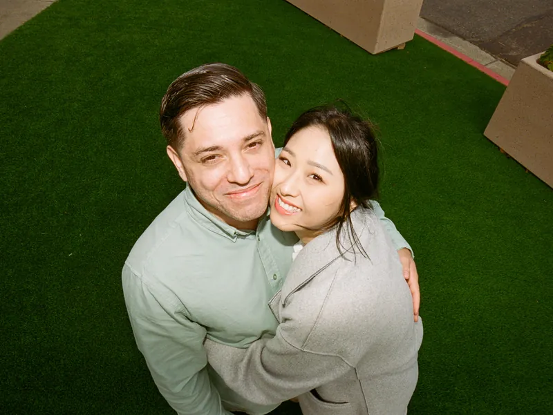 Eden and Luis cheek to cheek, smiling up at the camera