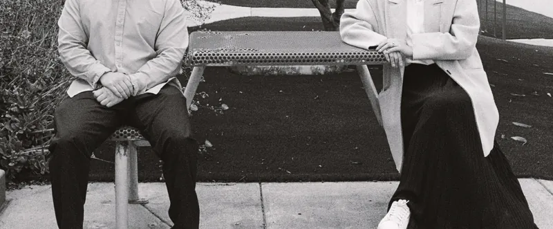 Black-and-white photo of Eden and Luis seated at a picnic table